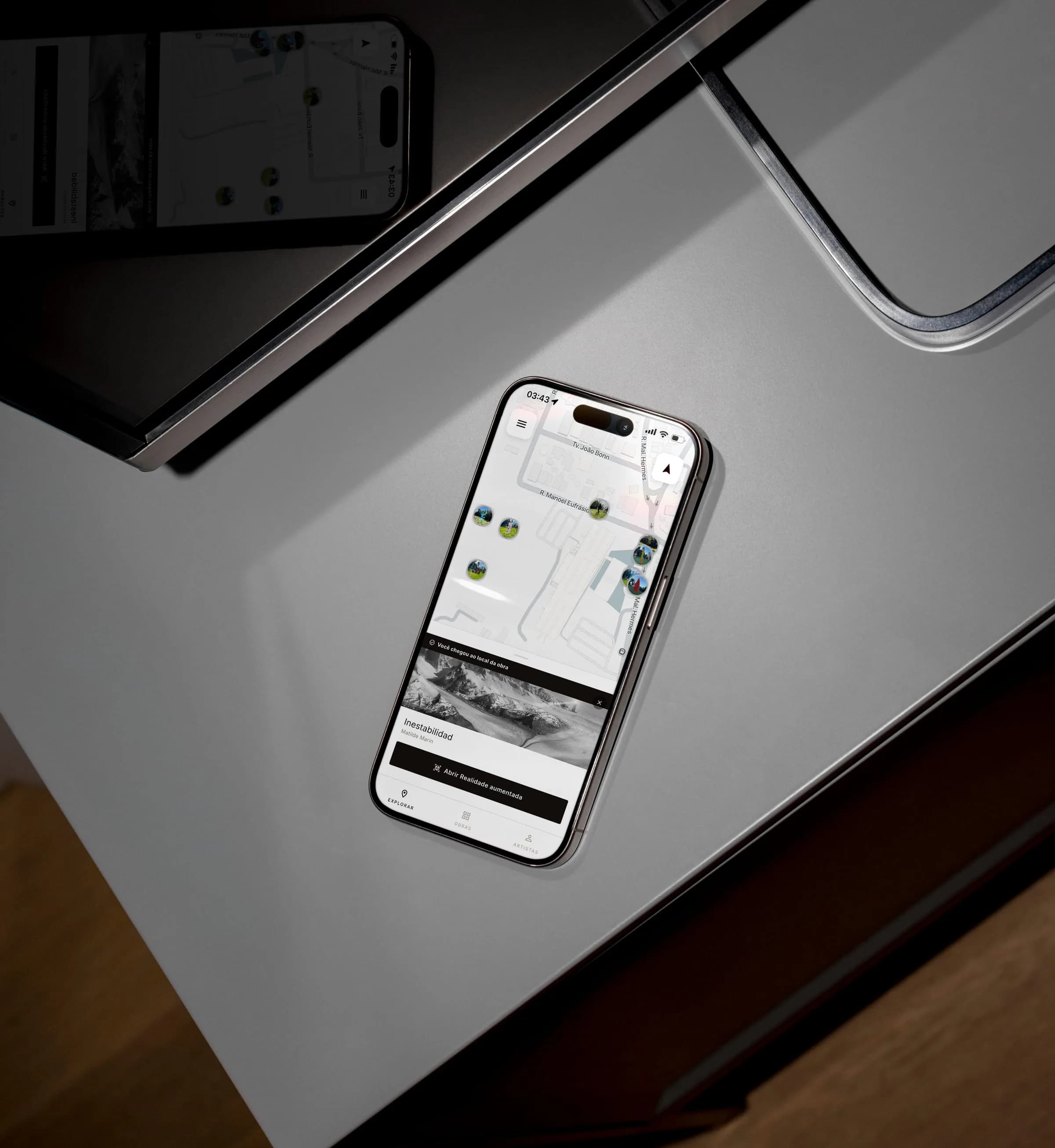 Aplicativo da Bienal de Curitiba em um iPhone, com o mapa das obras e o botão de realidade aumentada.